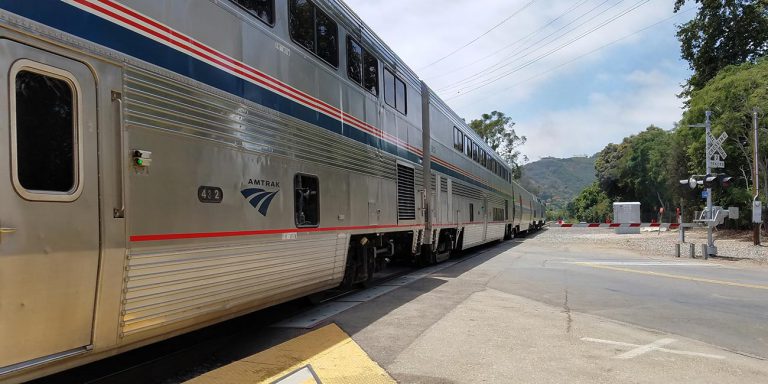 Amtrak train at railroad crossing.