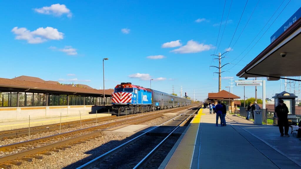 Blue and silver Chicago Metra train arrives at Route 59 train station.