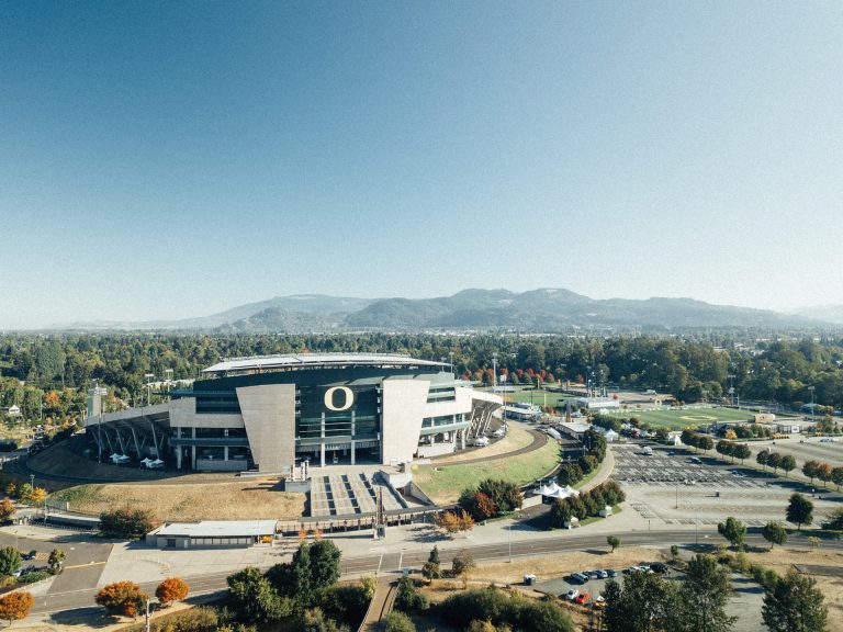 Modern Oregon stadium against hilled background.