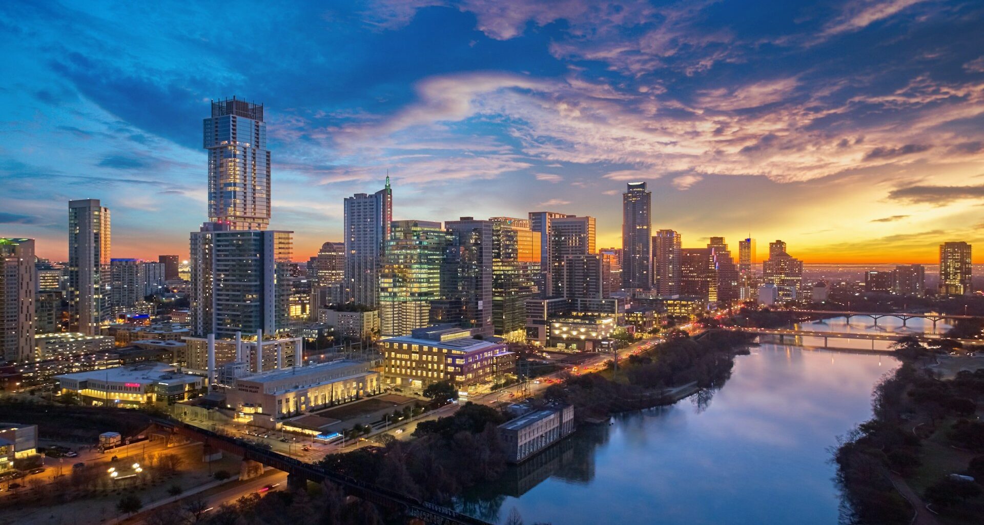 Austin skyline along the Colorado River during a colorful sunrise.